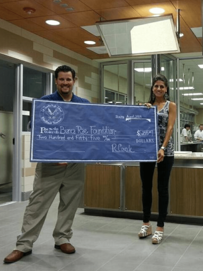 Webb, (l.) presents KESQ’s Bianca Rae, (r.) with a check for the Bianca Rae Foundation  